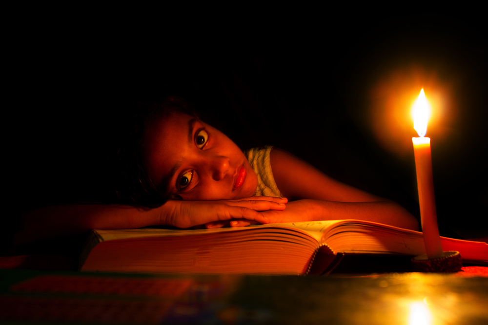 An,Indian,Girl,Trying,To,Study,In,Candle,Light,,Electricity,