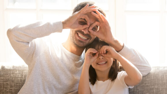 Pretty,Family,Father,Adorable,Daughter,Sitting,On,Sofa,Do,Funny