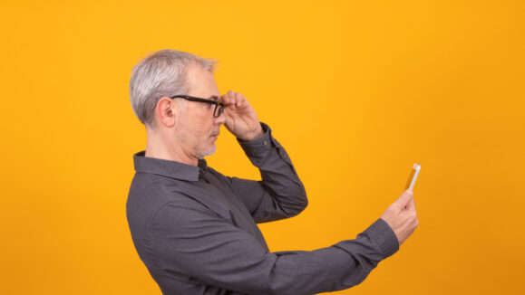 Adult,Or,Senior,Man,With,Mobile,Phone,Isolated,On,Color