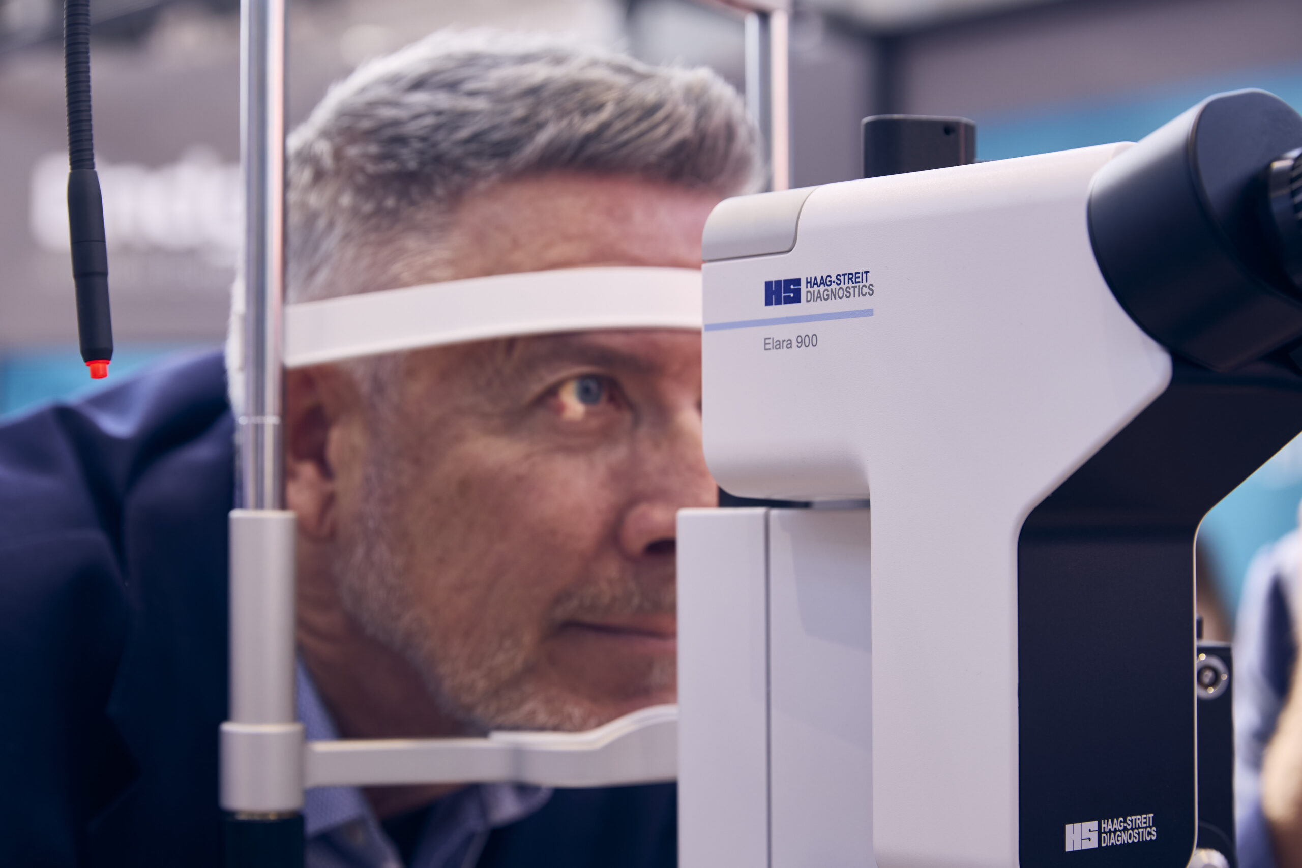 A man undergoing eye exam using Haag-Streit Elara 900 slit lamp